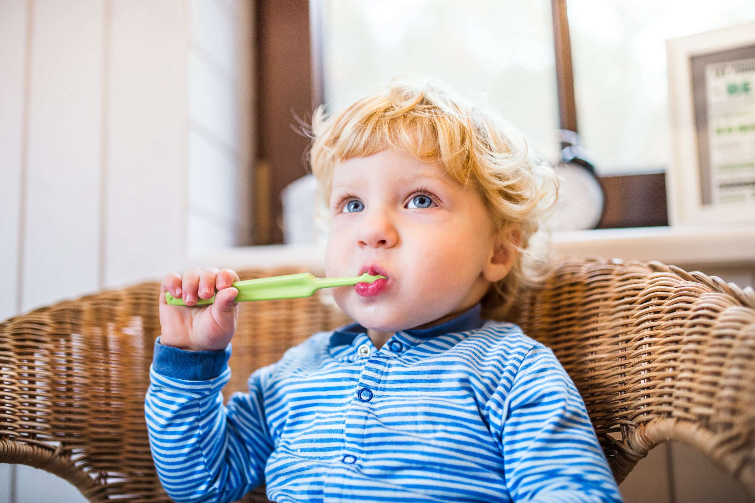 Jak zapobiec próchnicy - mały chłopiec uczący się szczotkować zęby
