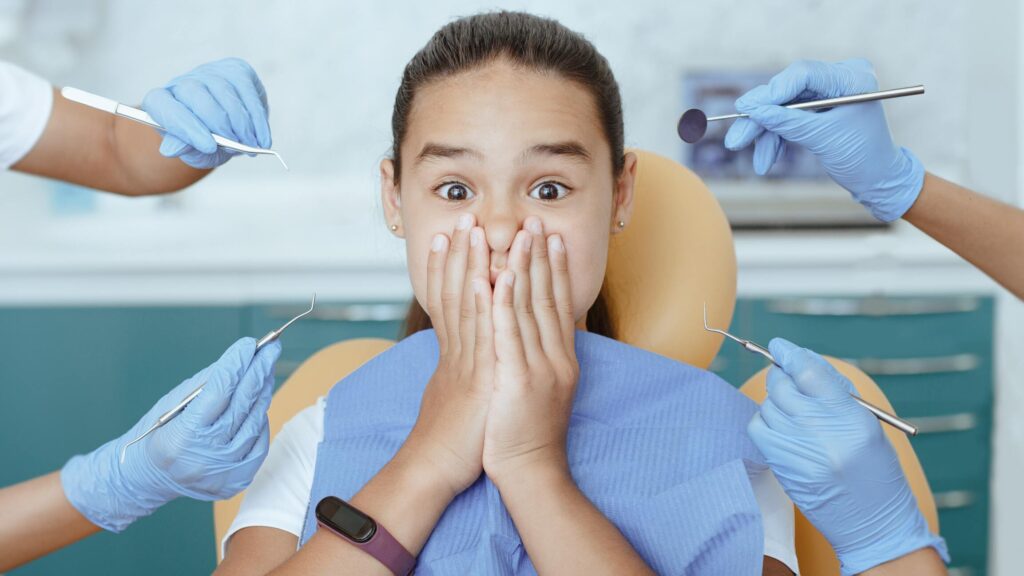 Zęby stałe u dzieci - Dziecko w gabinecie dentystycznym przed badaniem zębów