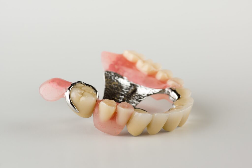 Górna proteza zębowa z metalowym zapięciem.